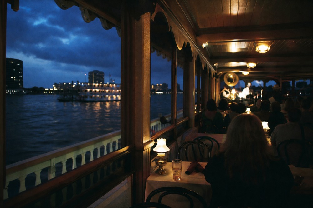 Evening jazz dinner cruise on the Mississippi, city lights behind the paddlewheel