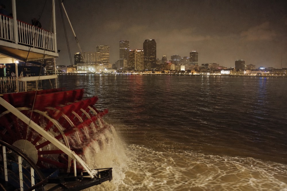 Twenty-five ton white oak paddlewheel churning brown Mississippi water at the stern of a steamboat