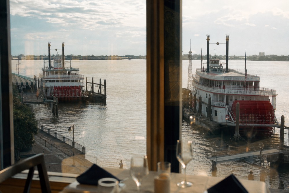 Two paddlewheel riverboats moored at separate New Orleans wharves along the same bend of the Mississippi