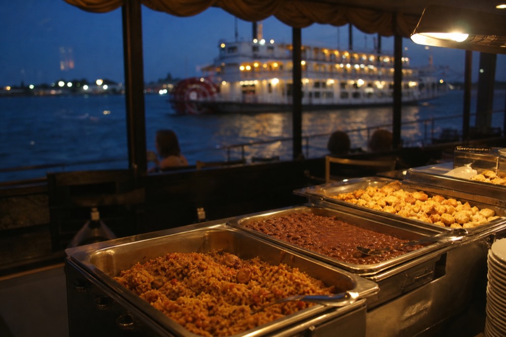 Creole buffet line on a riverboat with jambalaya, red beans and bread pudding in warming trays